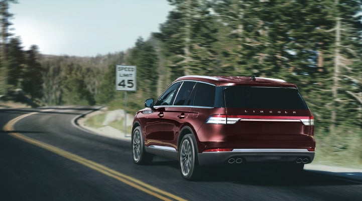 A 2024 Lincoln Aviator® SUV is being driven on a winding mountain road | Irwin Lincoln Laconia in Laconia NH