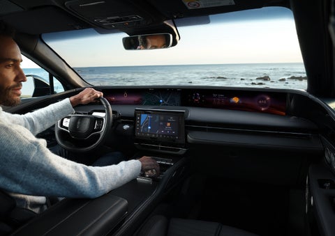 A driver of a parked 2024 Lincoln Nautilus® SUV takes a relaxing moment at a seaside overlook while inside his Nautilus. | Irwin Lincoln Laconia in Laconia NH